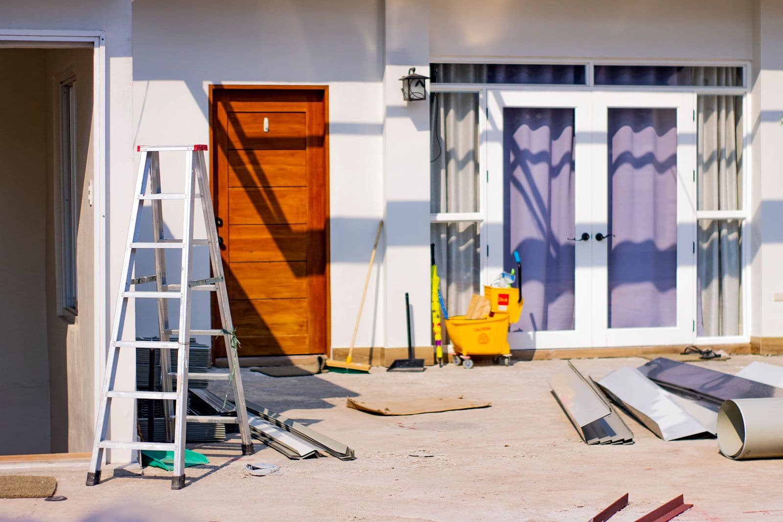 A home mid-renovation, a ladder beside a newly hung door